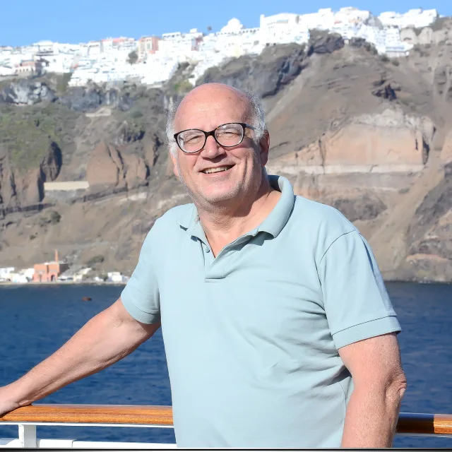 Travel advisor Michael Lissack standing on a bridge and smiling in light gray polo shirt.