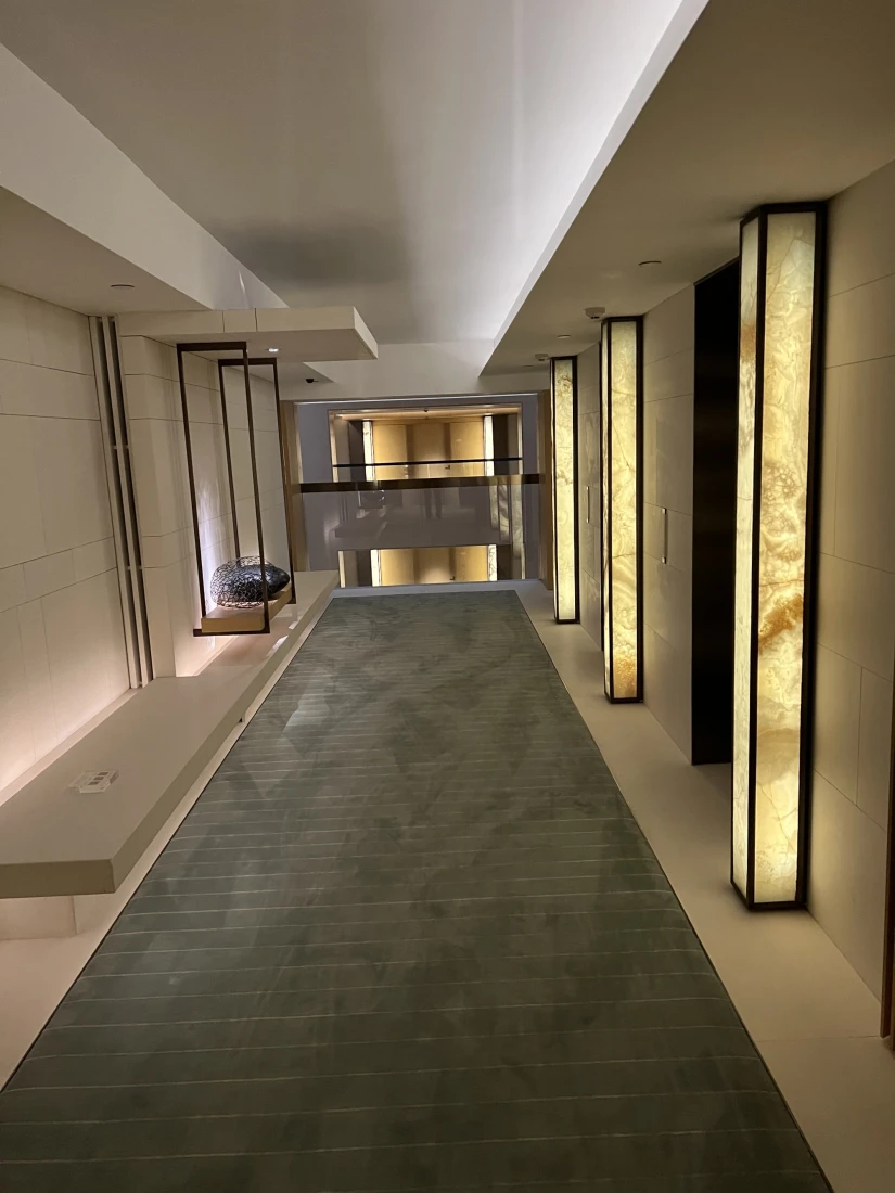 A view of the hotel's hallway, and lit-up elevator entrances.