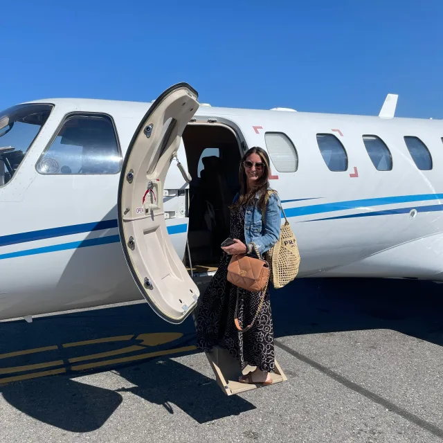 Picture of Ariann boarding a small plane while holding luggage