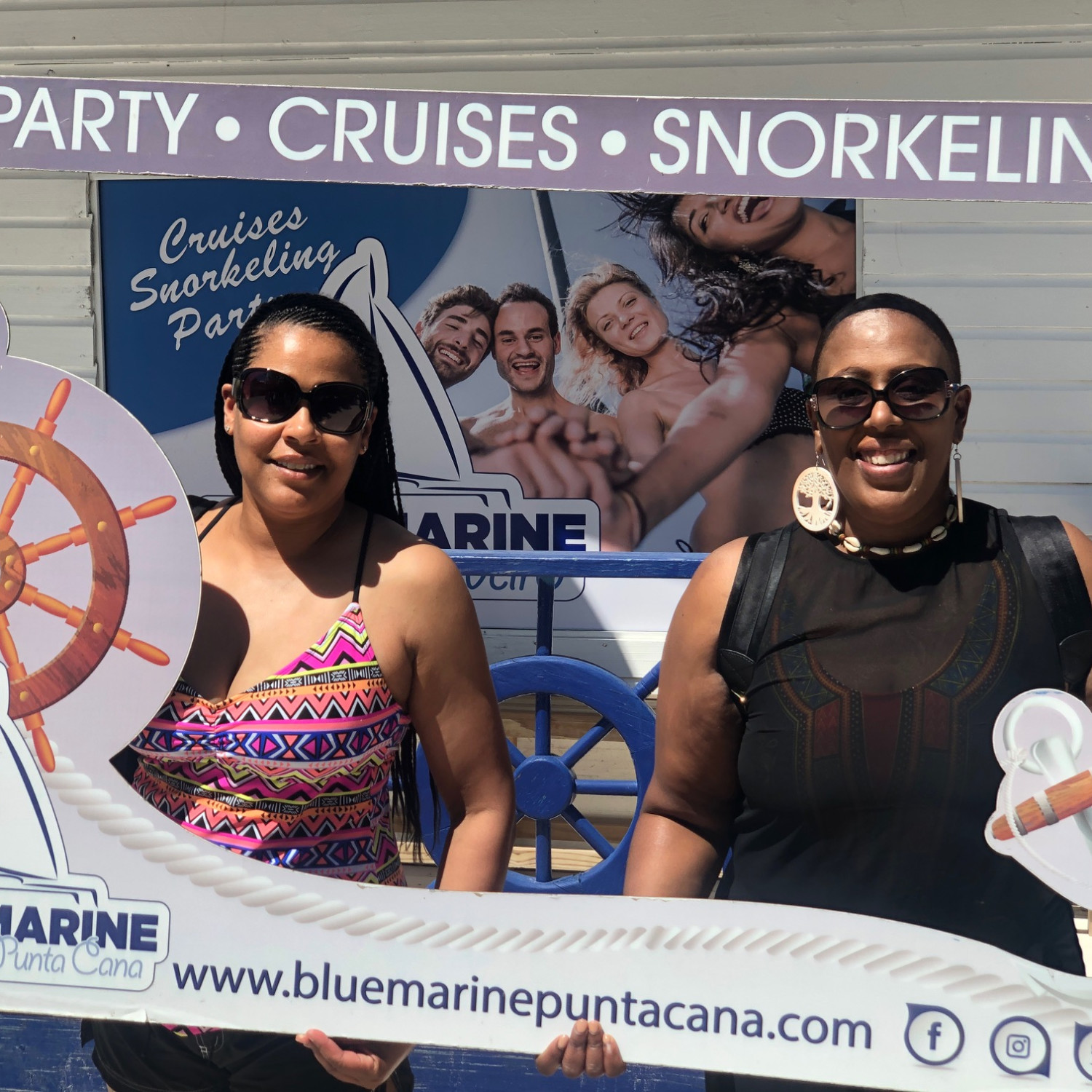 two women holding up a sign reading "party, cruises, snorkeling"
