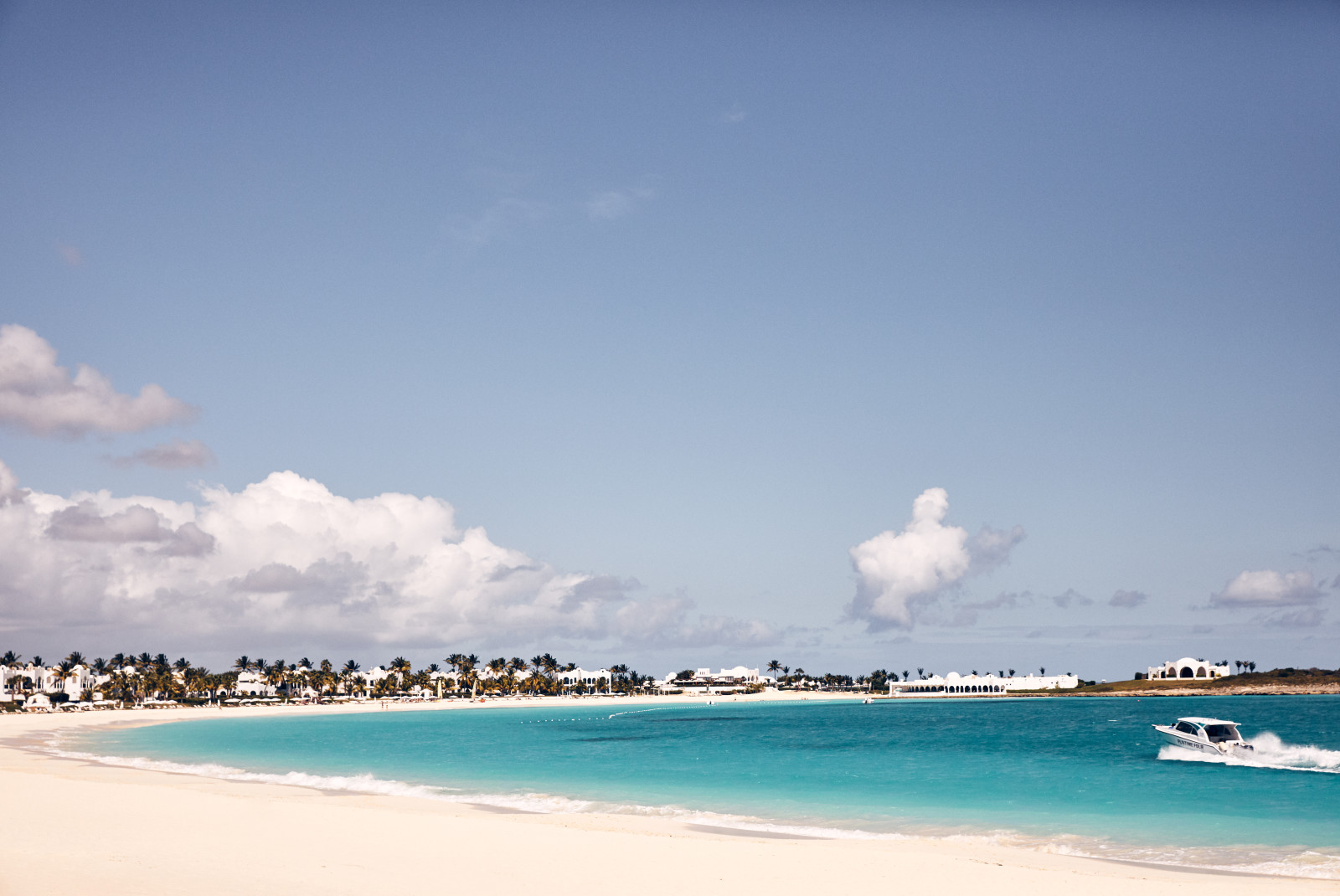 white sand beach with boats in the water during daytime