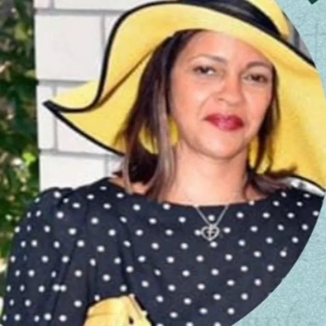 Sharon Johnson in a blue polka dot top, yellow hat and yellow earrings