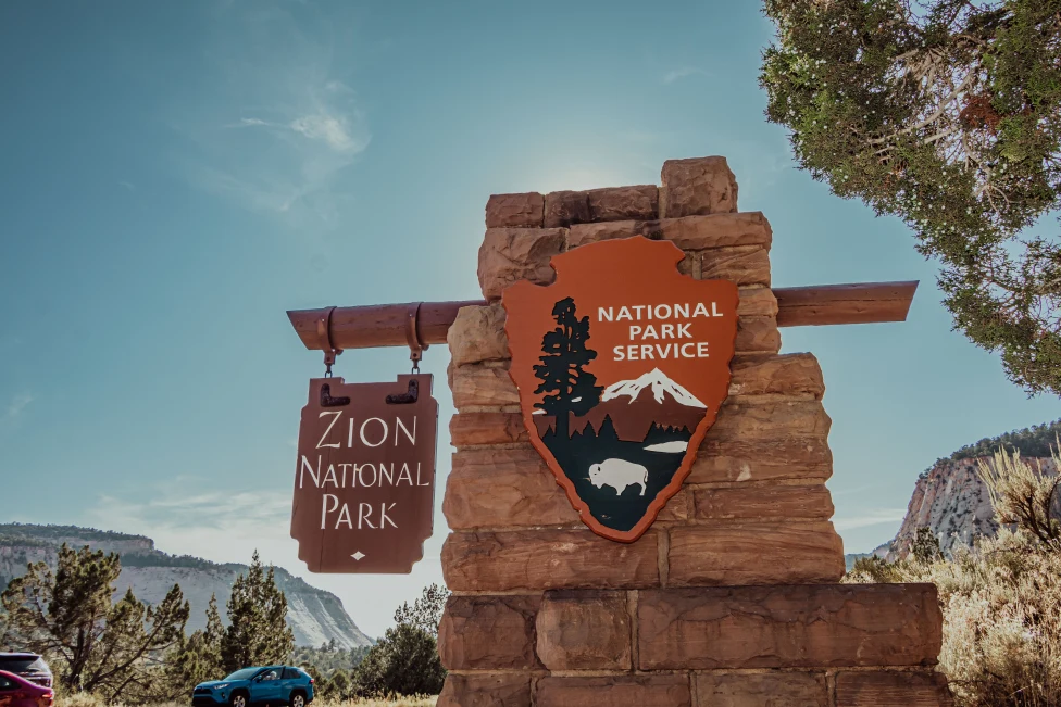 A board with writing Zion National Park