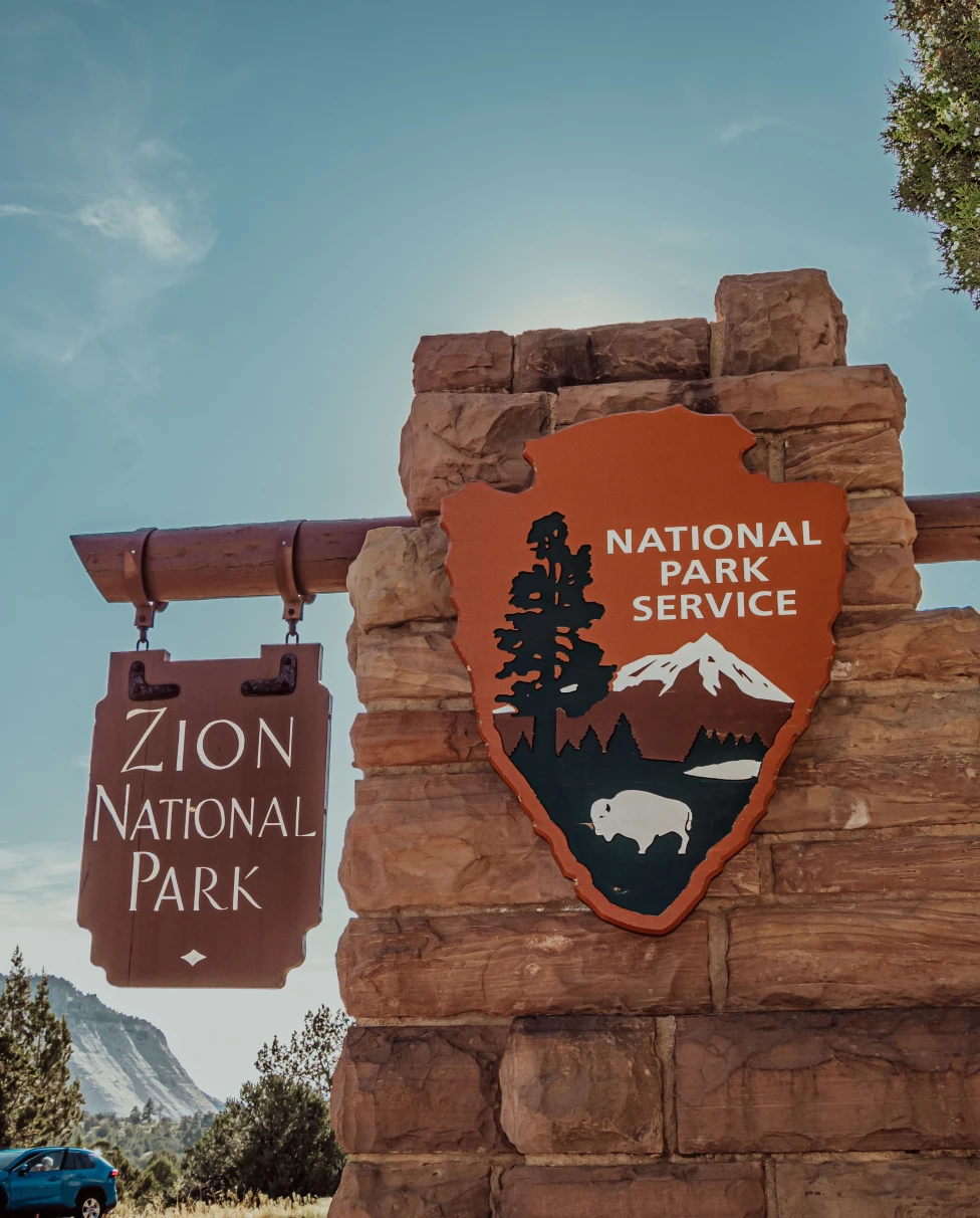 A board with writing Zion National Park