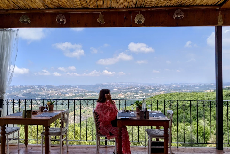 A woman looking over a landscape in Lebanon from a restaurant.