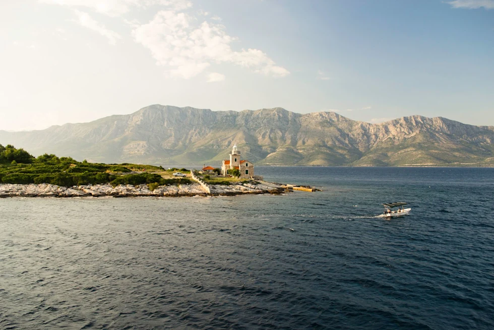 Beach with a boat and mountains at the background.