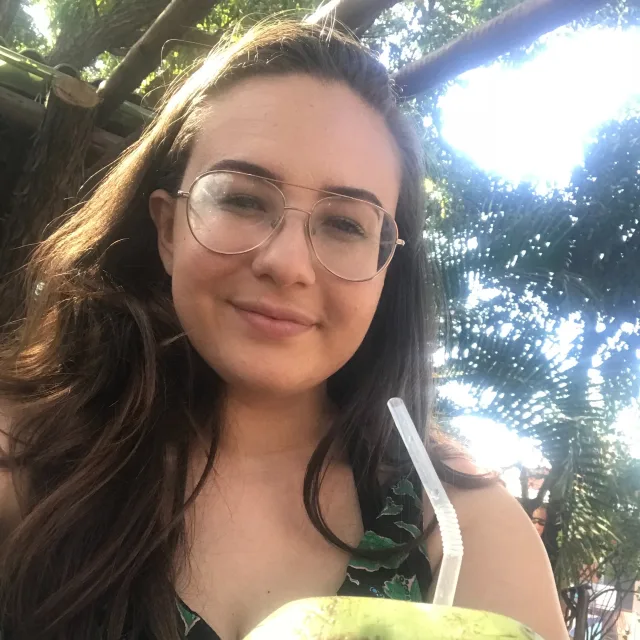 Travel Advisor Clara Raposo drinking from a coconut.