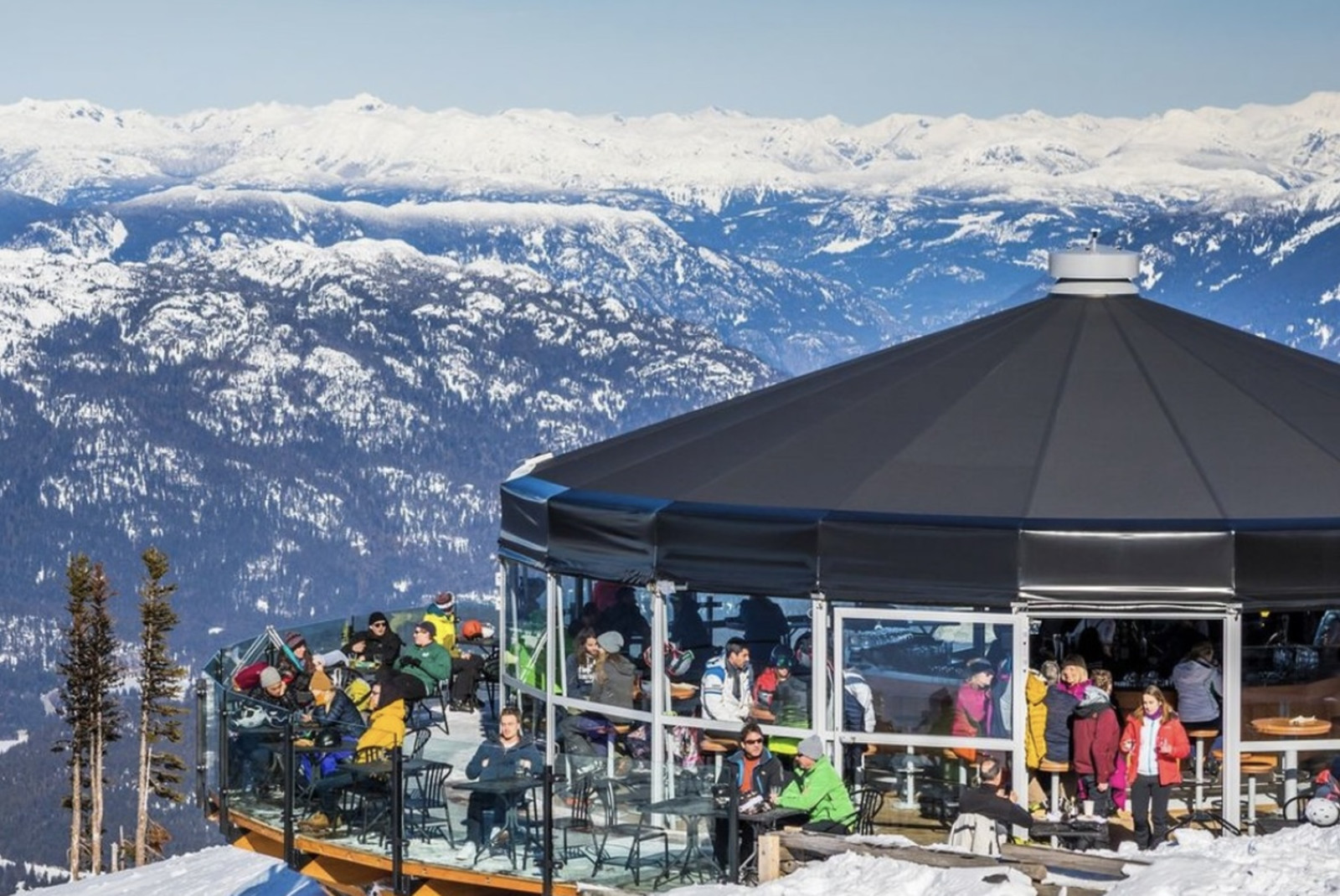 People outside building with snowy mountains in the background