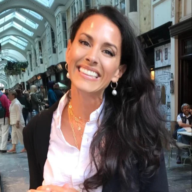 Travel Advisor Andrea Mertz with a white shirt and black jacket inside a market.