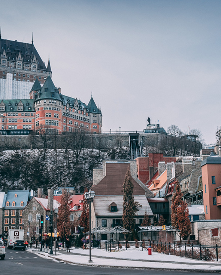 Quebec City snow covered streets in Canada with white cars and orange green and blue buildings