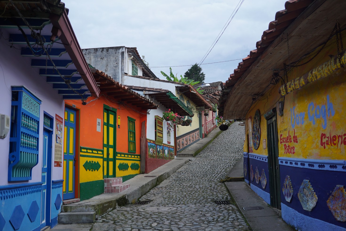Cobblestone street lined with small buildings with colorful walls