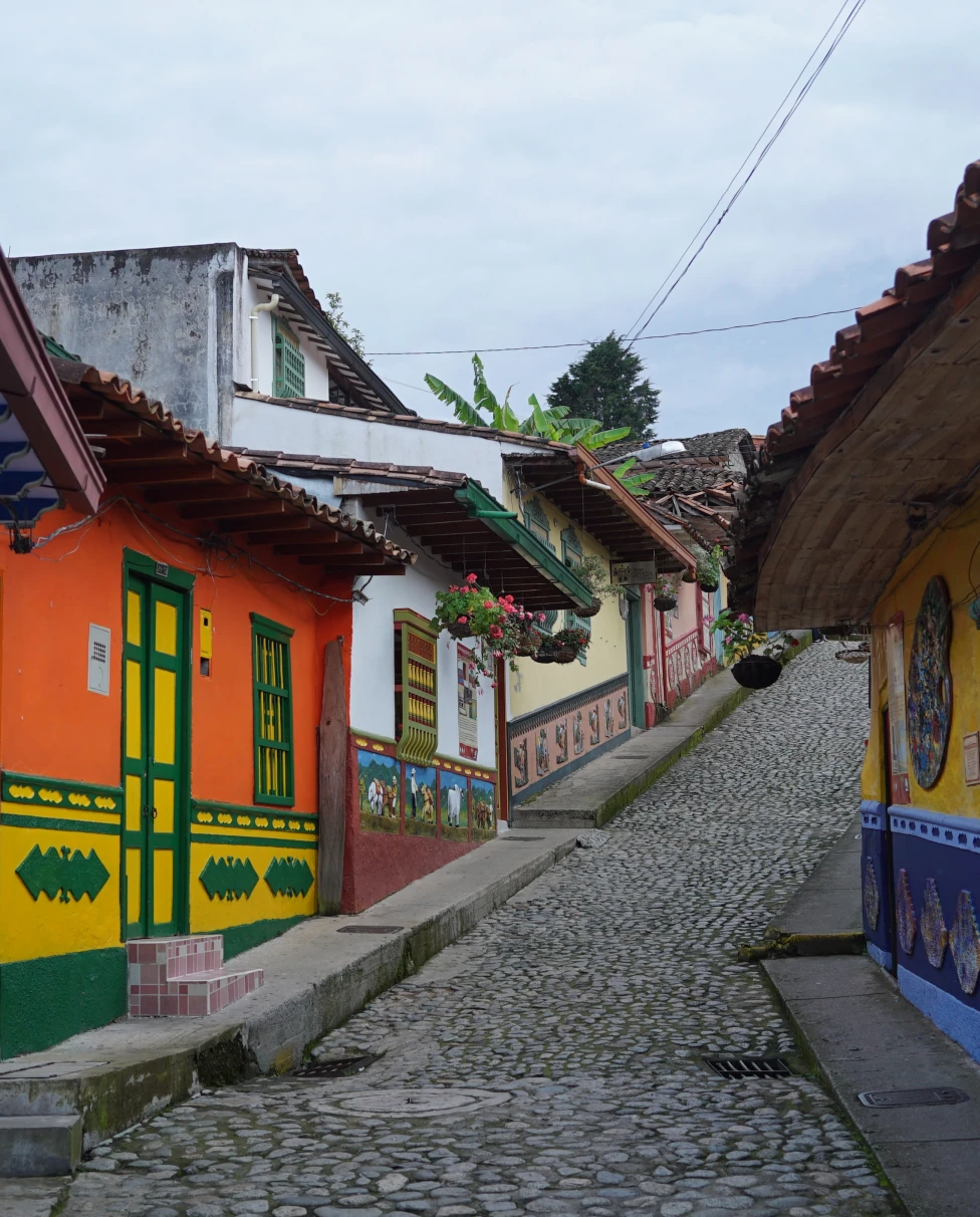 Cobblestone street lined with small buildings with colorful walls