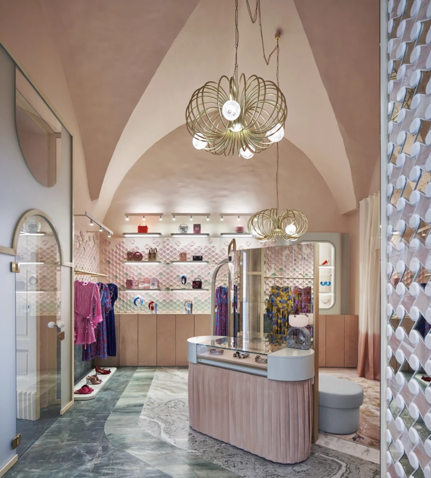 a chic boutique with vaulted ceilings, pink walls, and a pink check-out counter