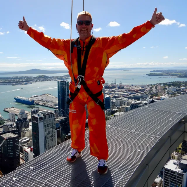 Travel Advisor Ed Munz with an orange jumpsuit, standing on a sky bridge.