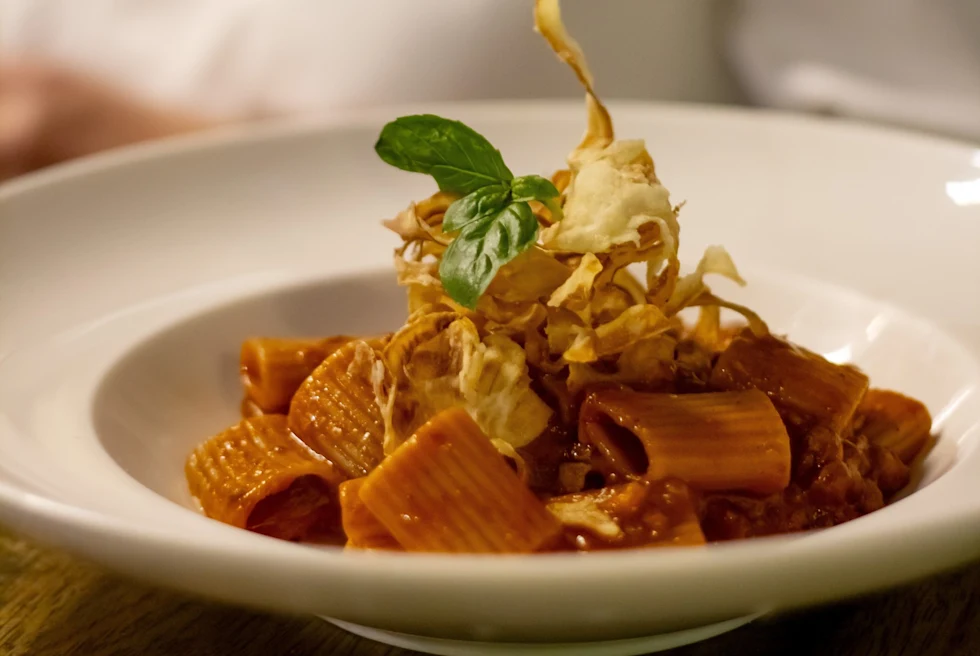 A white plate with pasta.