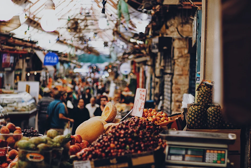 bowls with fruits and people walking around in the distance