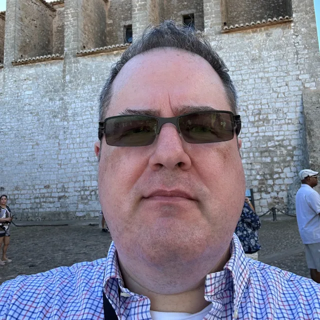 Travel advisor John Zebley in front of a tall stone structure
