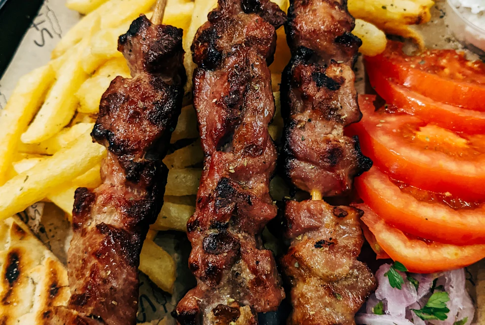 Chicken on a plate with fries onions and tomato