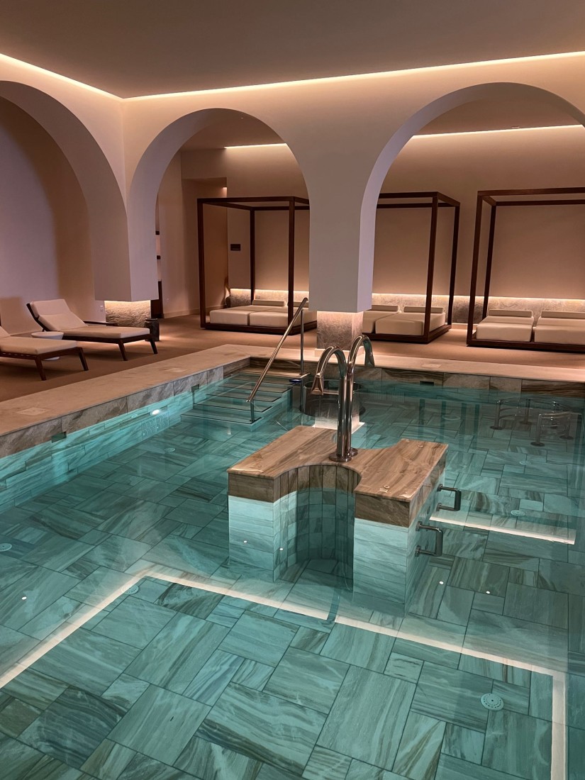 An indoor hotel pool with loungers