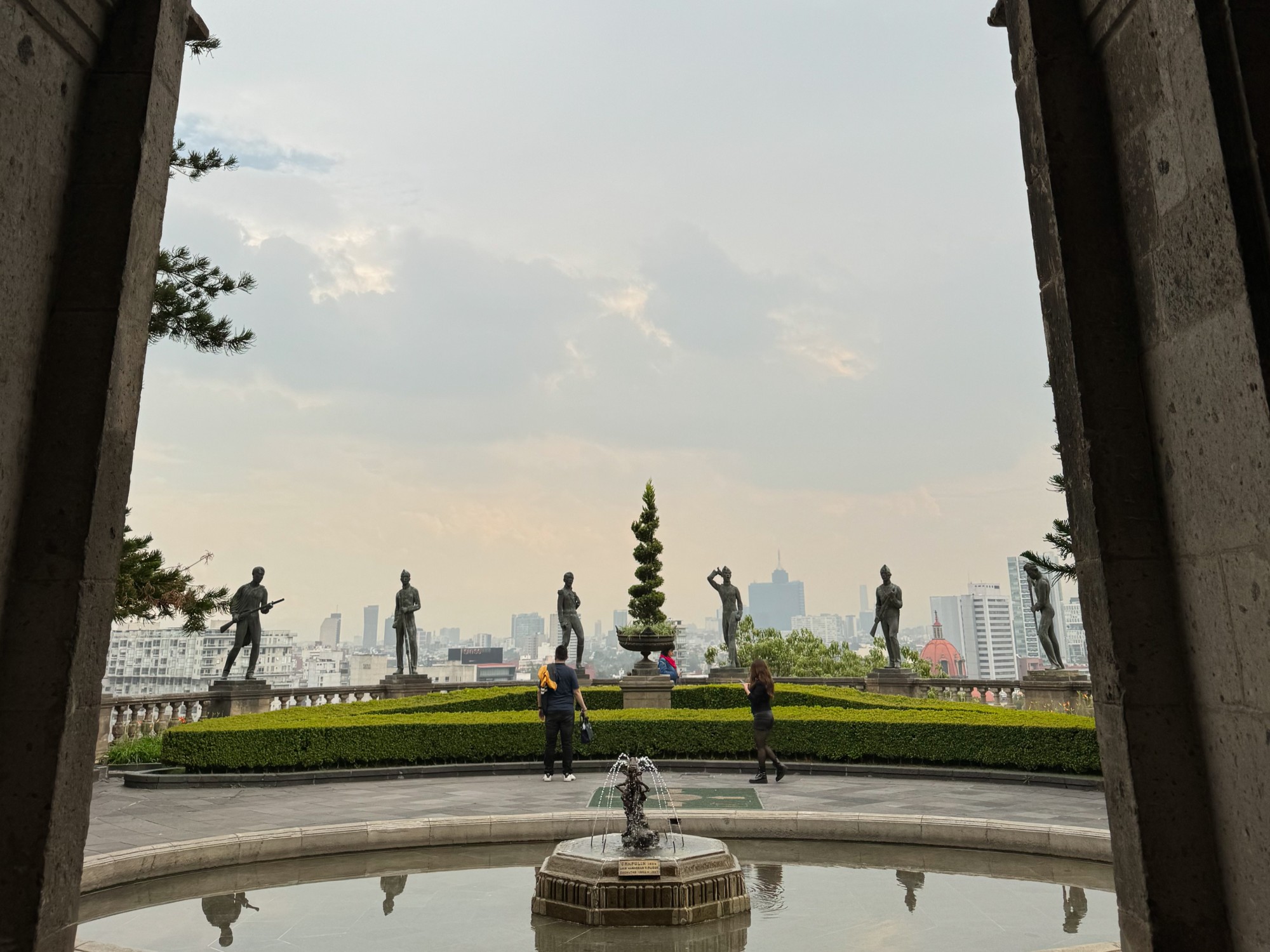 View of fountain and statues through an arch.