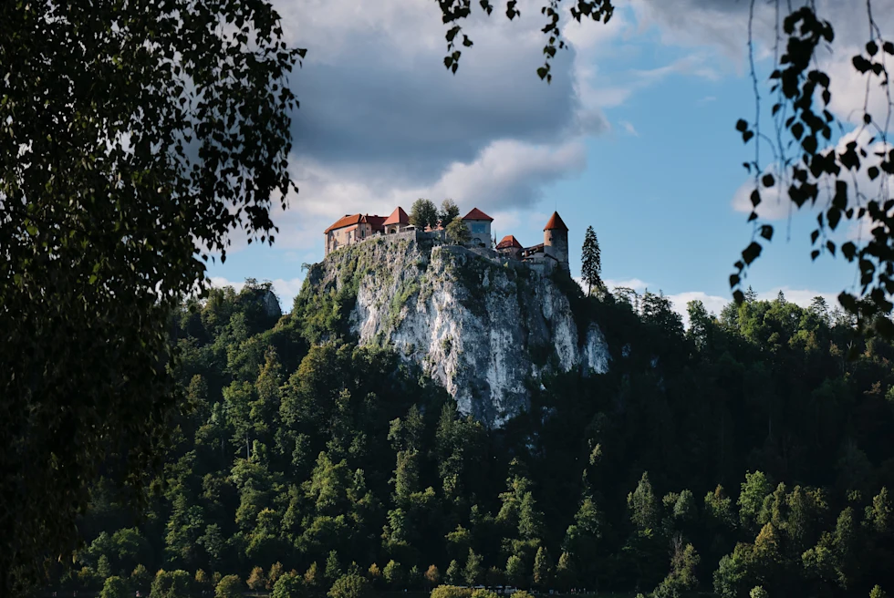 A castle perched on a hill and surrounded by vegetation in Slovenia.