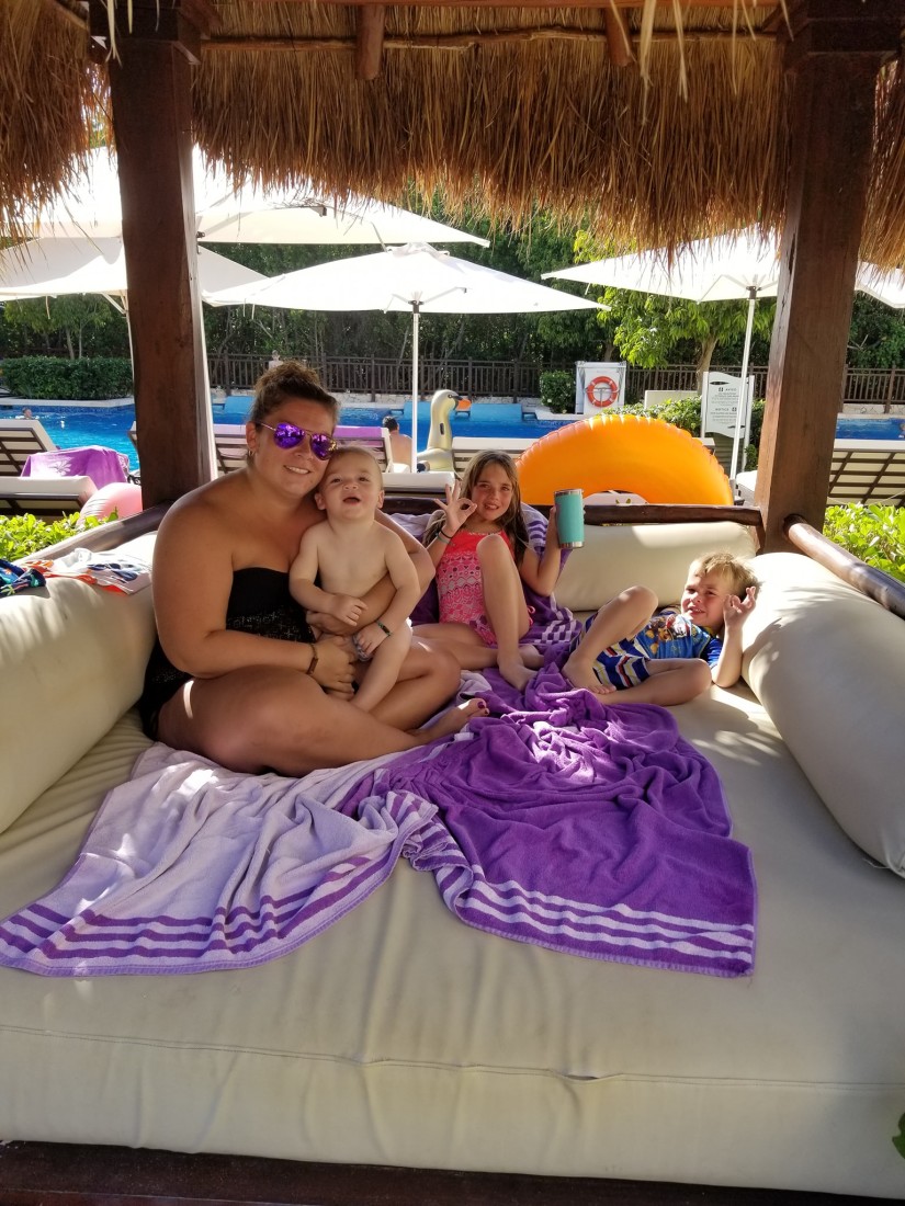A lady posing with kids on the pool side
