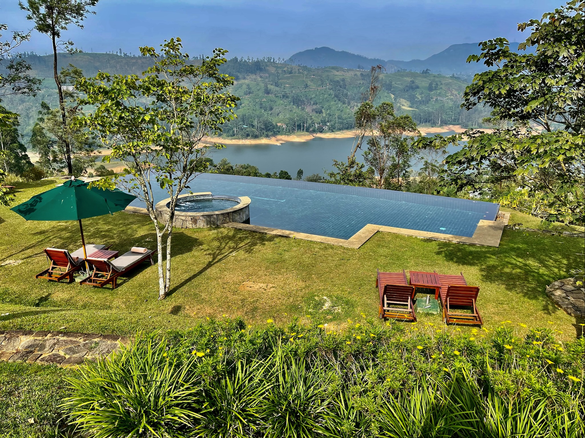 A view from a hotel room with an infinity pool hanging over the mountainside. 
