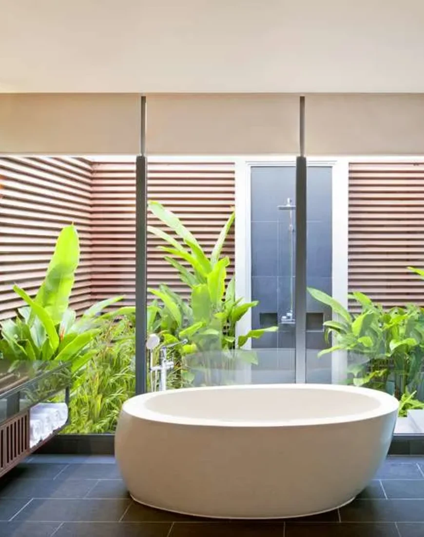 a large white bathtub in a bathroom with floor-to-ceiling windows