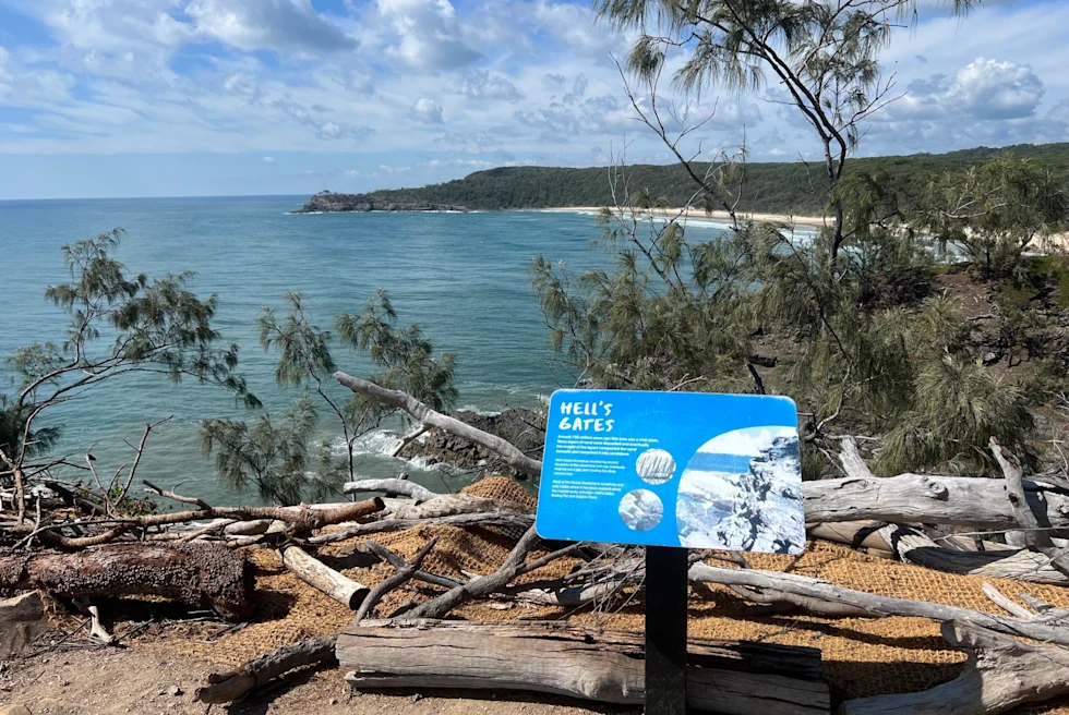 view over the coast with a sign that reads, "Hells Gate"
