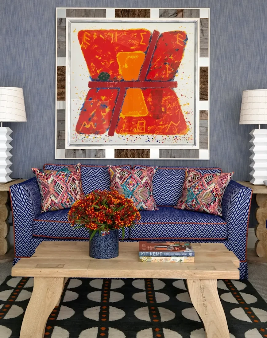 a funky seating area with blue furniture and a red abstract painting