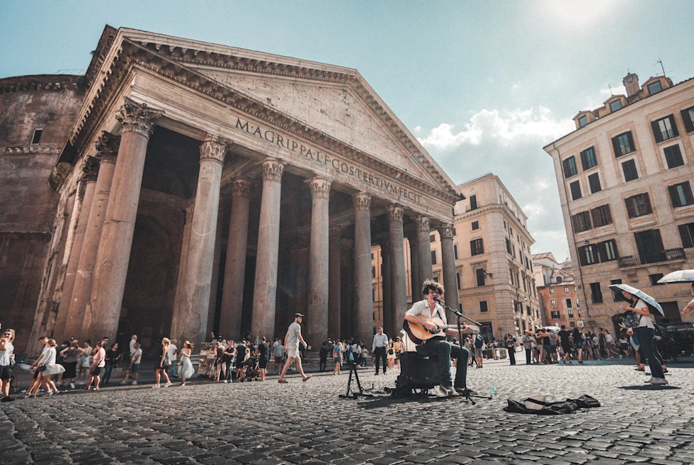 people standing outside of large stone building during daytime