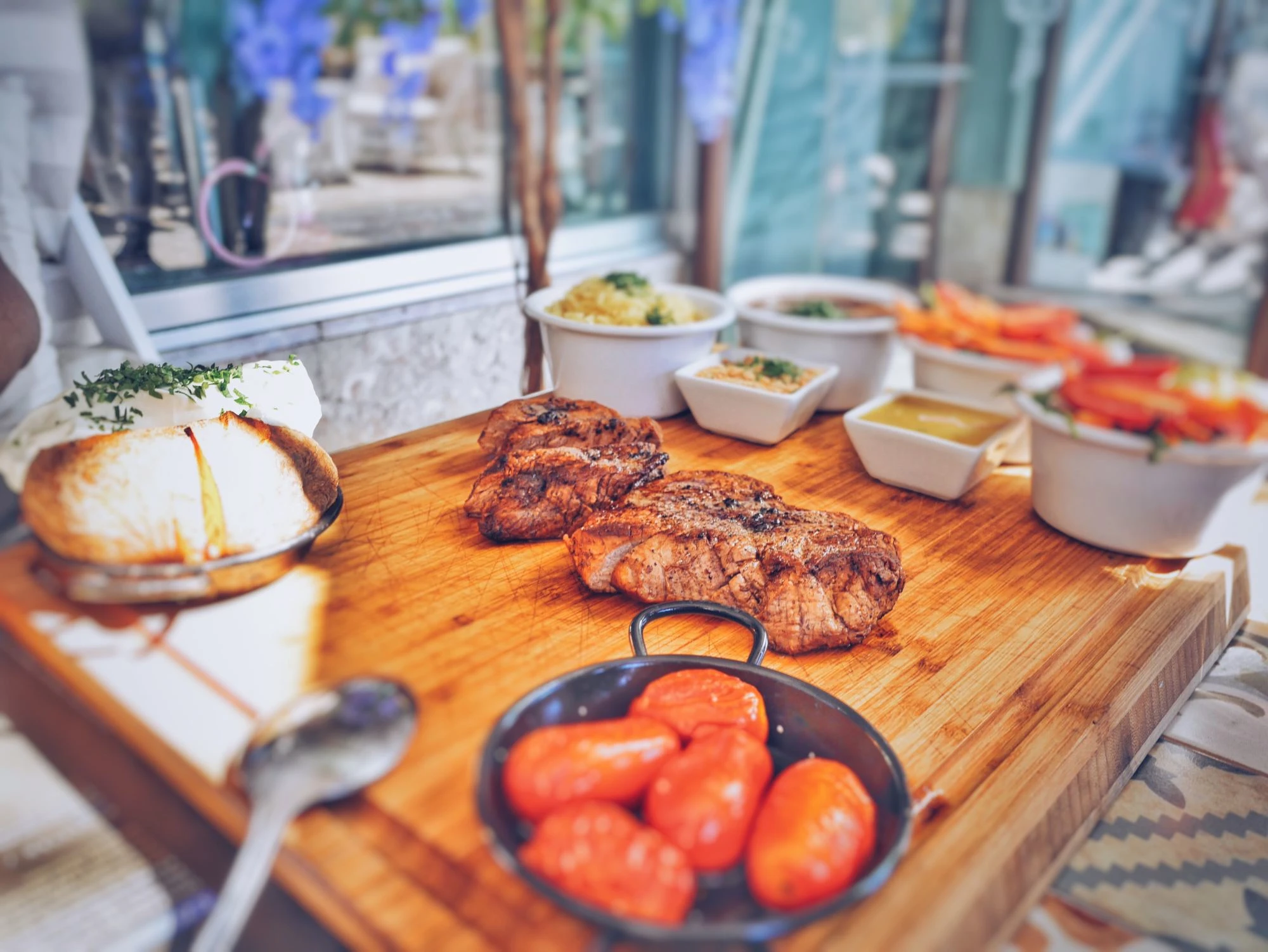 A tray with steak, bread and accessories. 