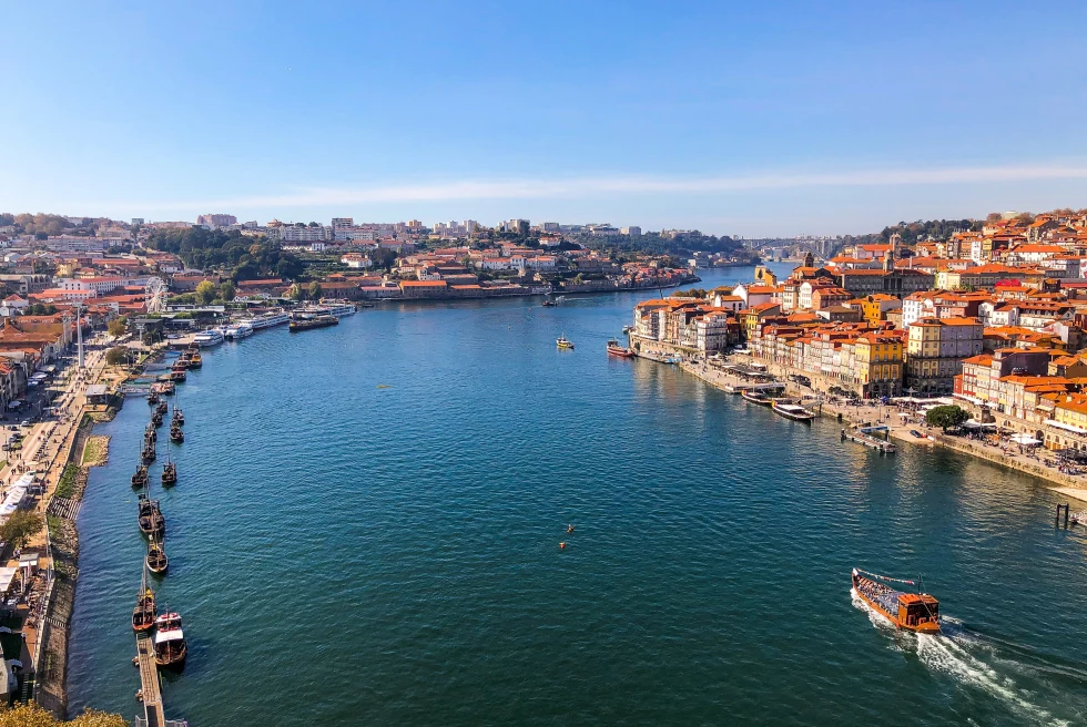 People boating in the river passing through the middle of the city.