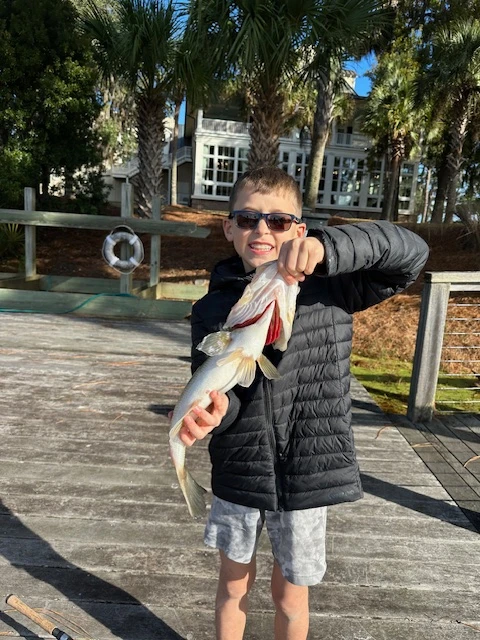 The kid holding a fish