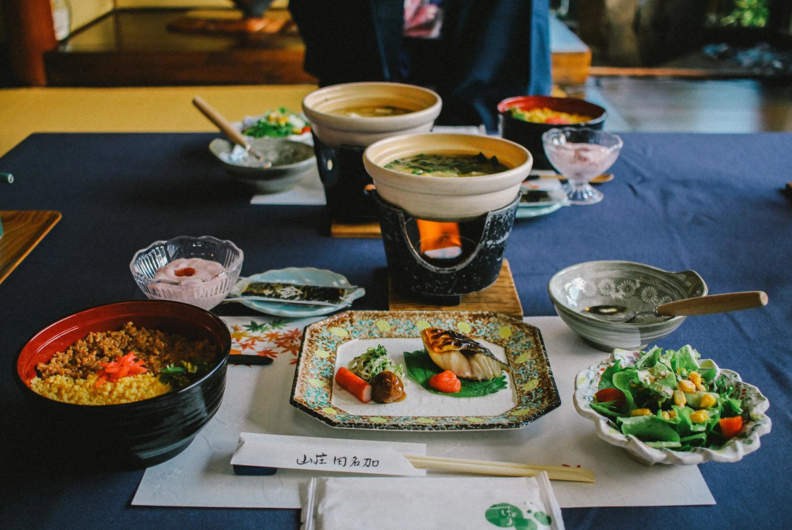 traditional Japanese tea meal with multiple dishes on a wooden table  