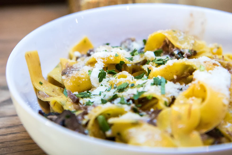 White bowl filled with pasta on a wooden table
