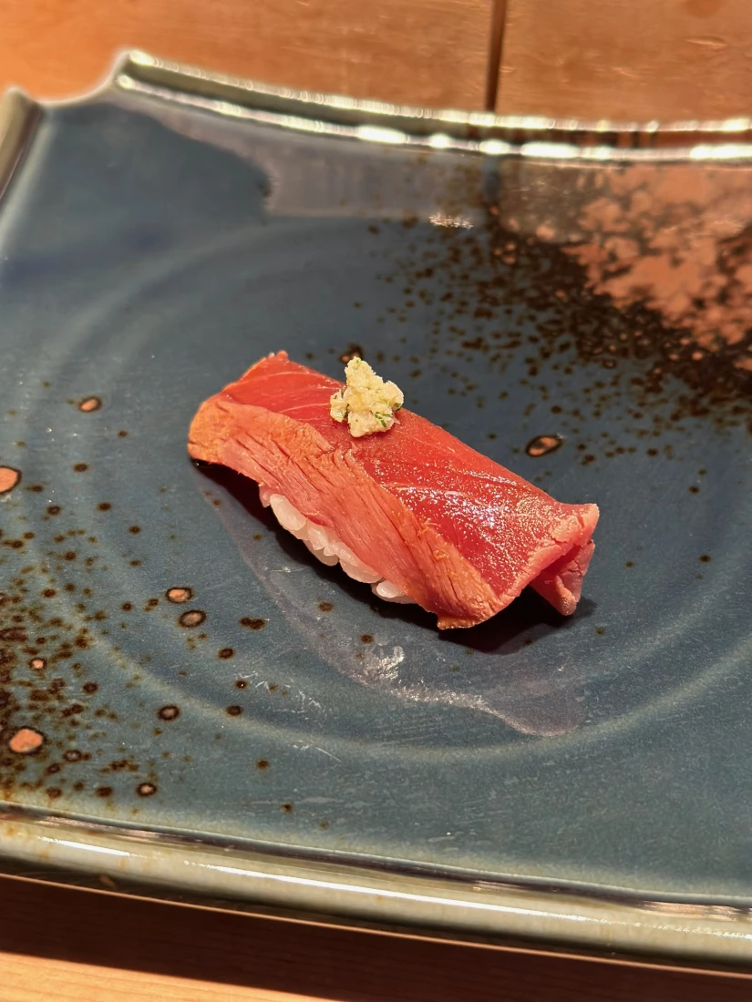 A piece of sushi on a blue plate (Otaru)