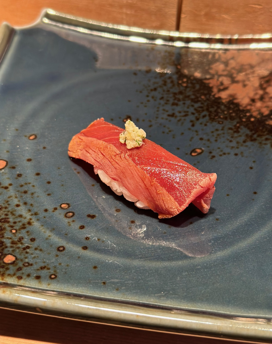 A piece of sushi on a blue plate (Otaru)