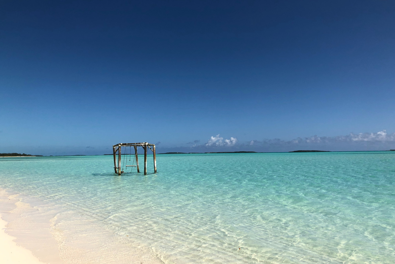 Swingset in the ocean with a blue sky in Exumas