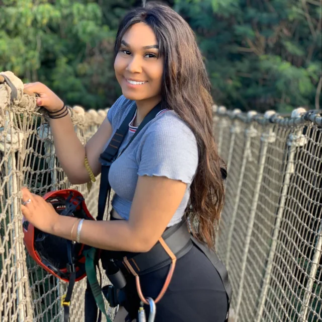 Travel advisor Brianna Marcial posing on a string bridge with a helmet in hand.