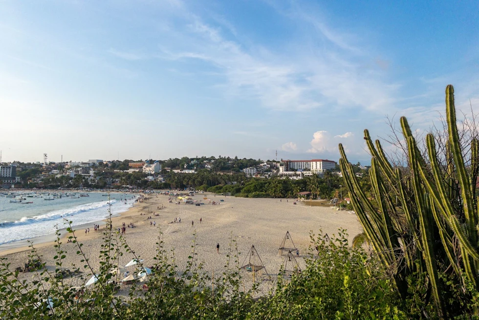 the bay of a coastal town with a populated beach during the day