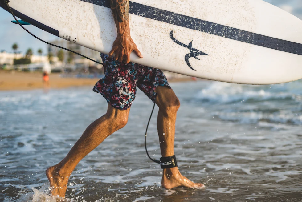 Guy holding a surf board in Cost Rica.