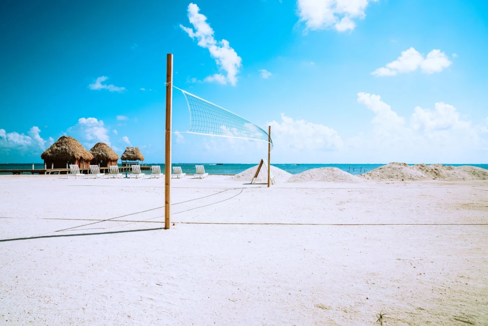white sand beach with empty volleyball net on a clear blue day