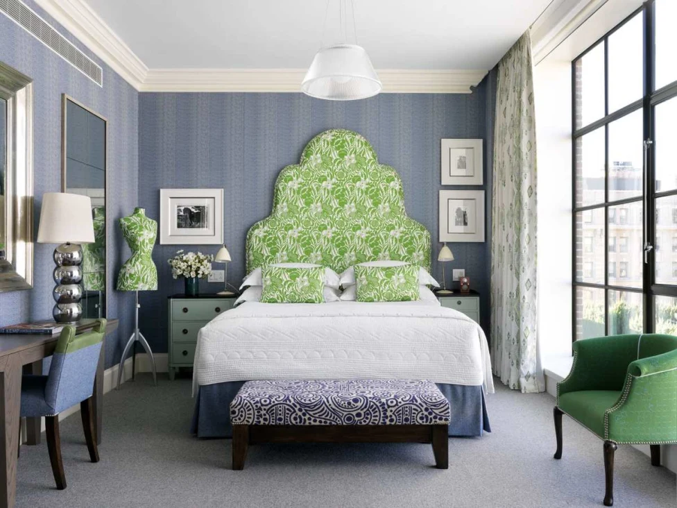 a bed with white linens and a bright green backspalsh