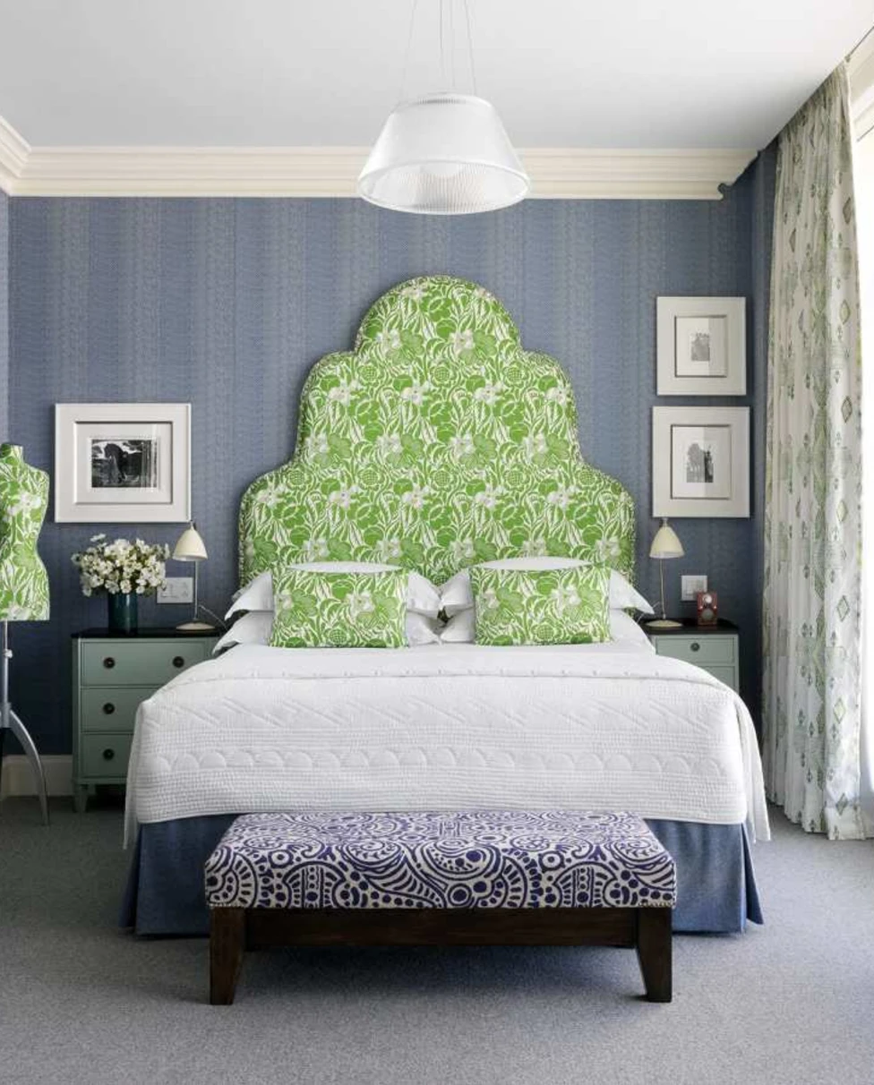 a bed with white linens and a bright green backspalsh