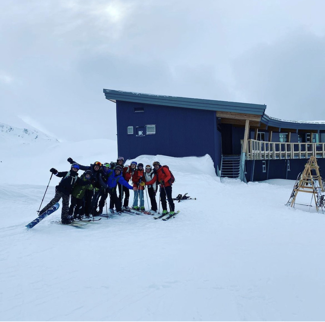 group standing in front of building on snowy mountain