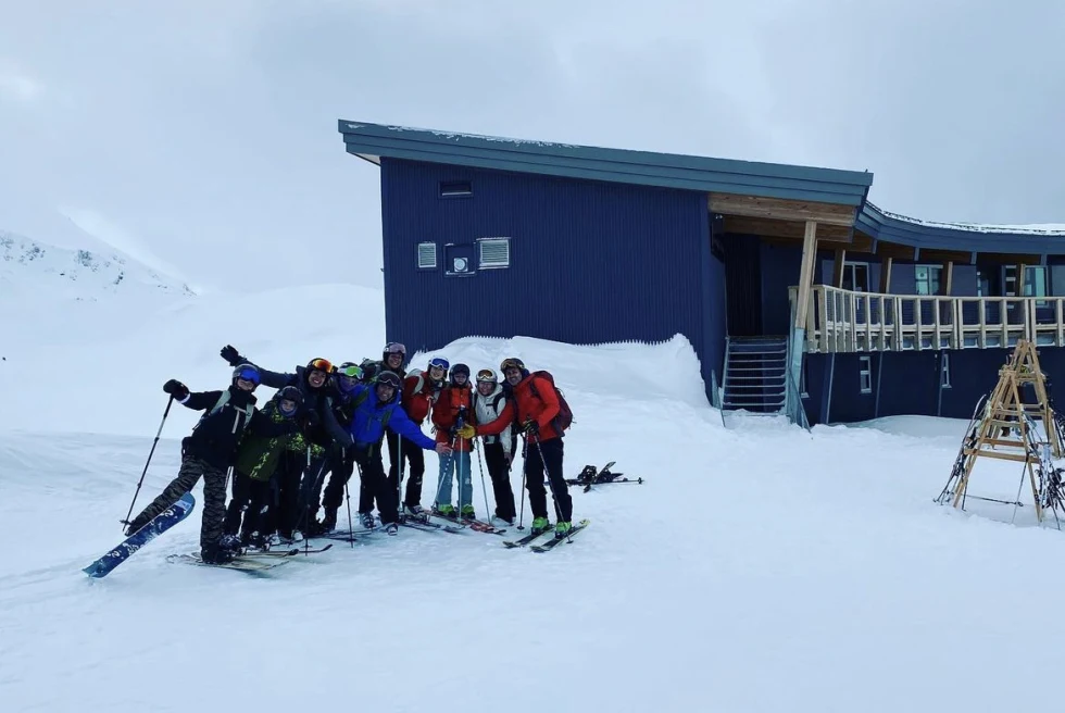 group standing in front of building on snowy mountain