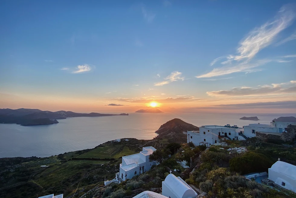 White houses overlooking body of water during sunset