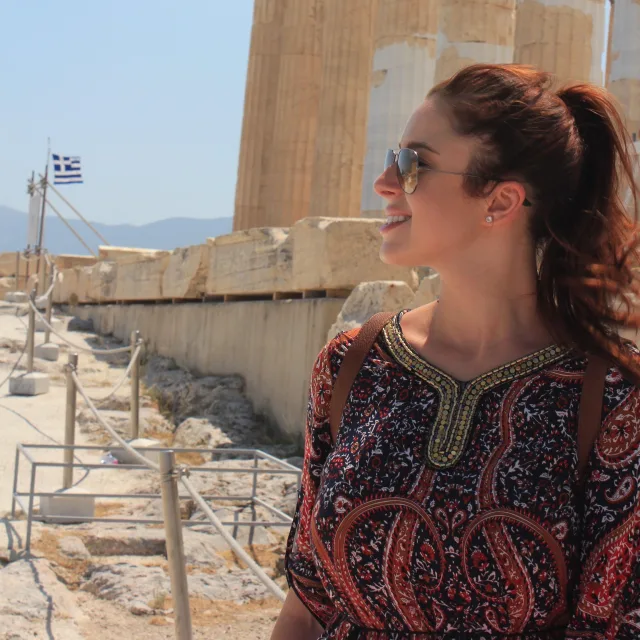 Travel Advisor Siane Chirpich in a red paisley top in front of ruins.