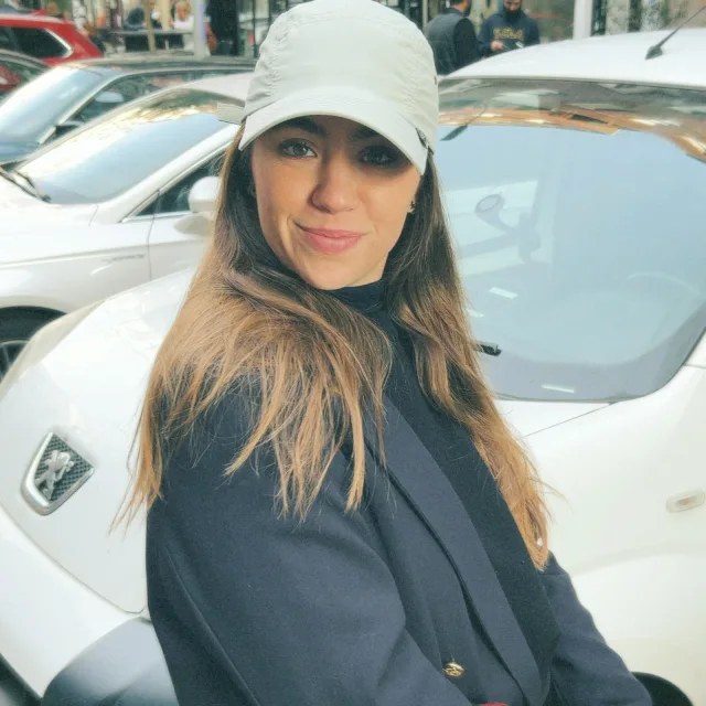 Travel Advisor Natalia trifnovic standing near white car in p-cap. 